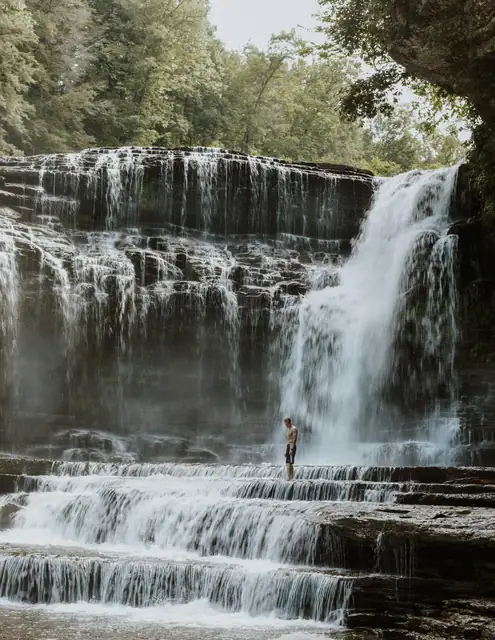 A stunning waterfall in Tennessee with a lone visitor experiencing its beauty.